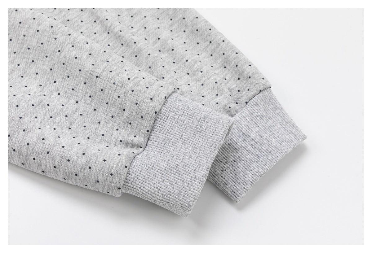 Close-up of a light gray dotted sleeve with a ribbed cuff.