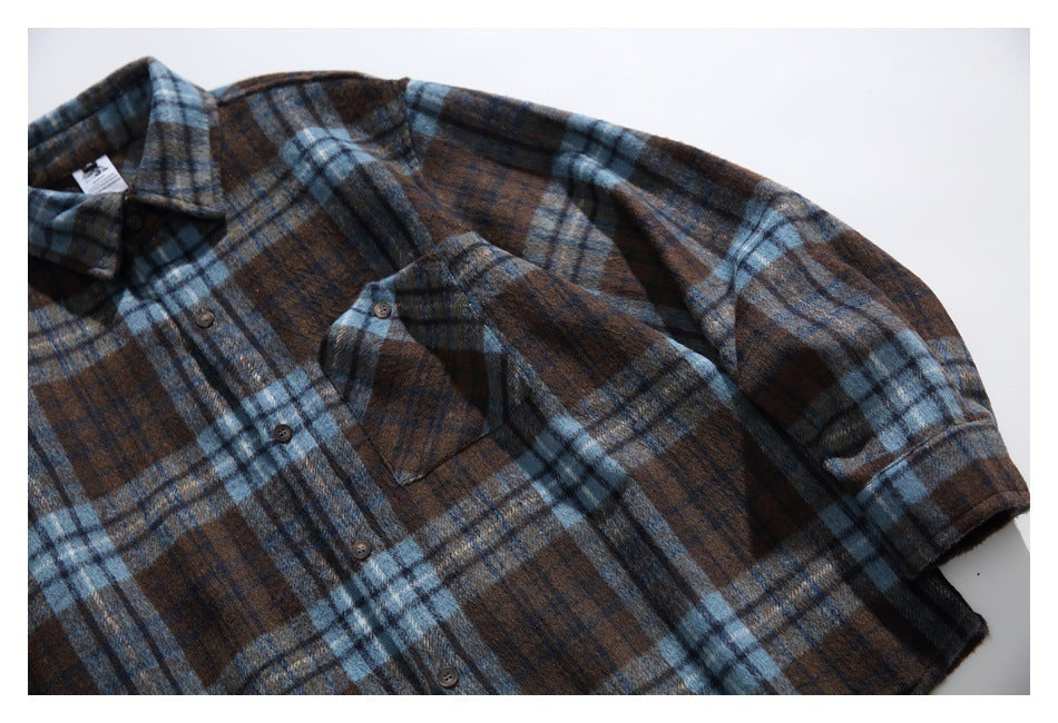Close view of the plaid shirt front, chest pocket, buttons, and one sleeve.
