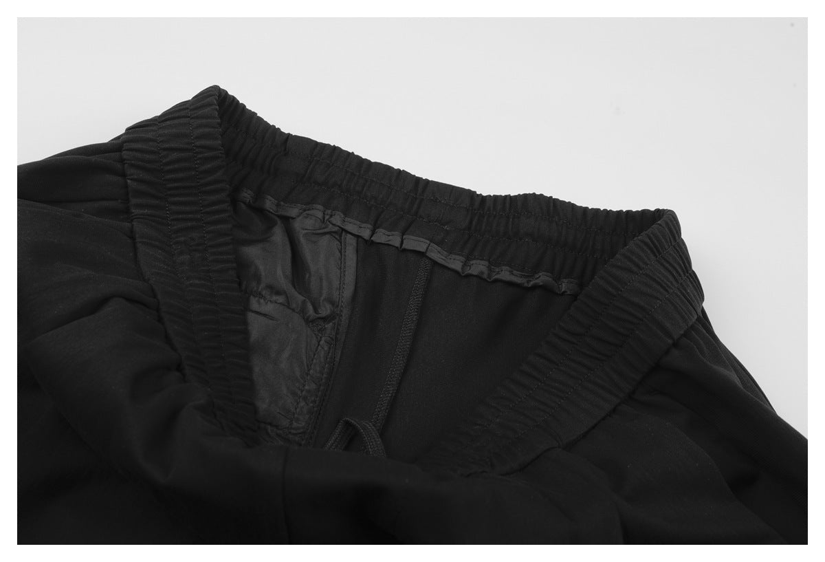 Inside view of black trousers showing the elastic waistband and drawstring.