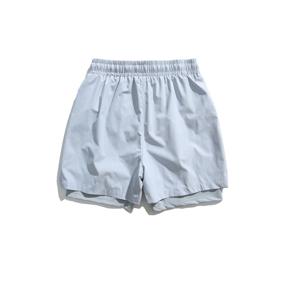 Back view of pale blue-gray shorts with an elastic waistband and layered hems.