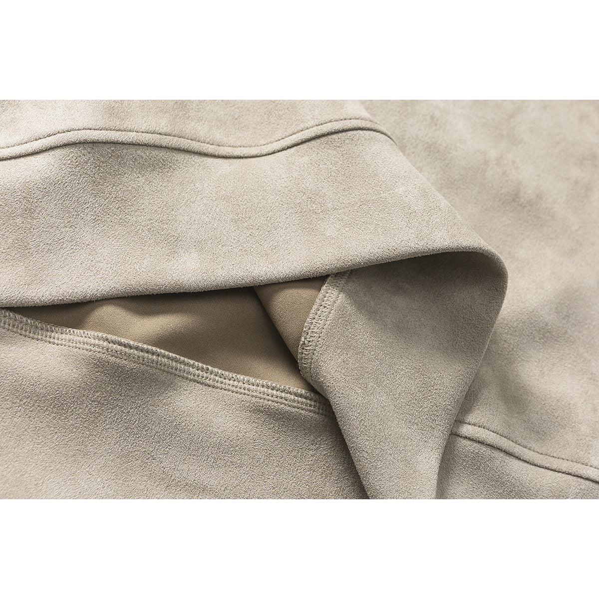 Close-up showing the taupe sweatshirt’s fabric, folded edge, and stitching.