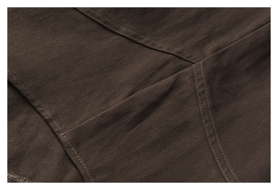 Close-up of dark brown garment panel with intersecting stitched seams.