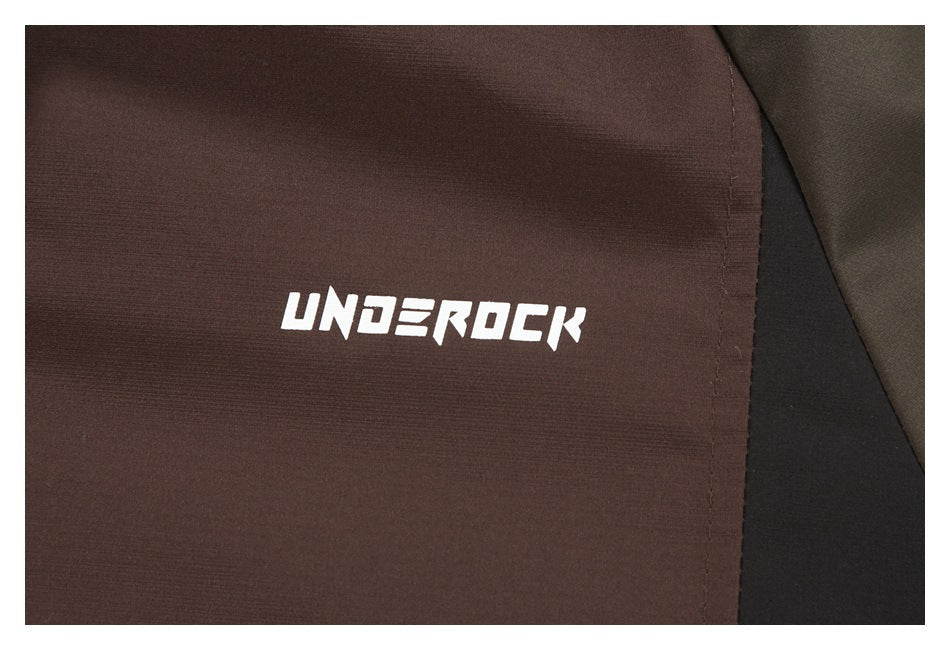 Close-up of the brown jacket fabric with a white UNDEROCK logo and dark contrasting panels.