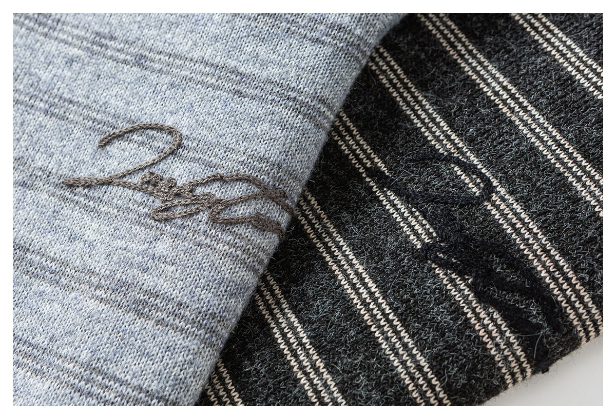 Close-up of gray heathered knit with dark script embroidery beside charcoal fabric with cream stripes.