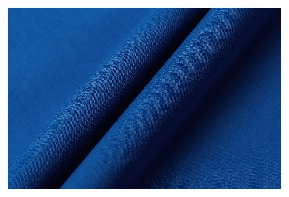 Close-up of blue fabric folded diagonally, showing its fine woven texture.