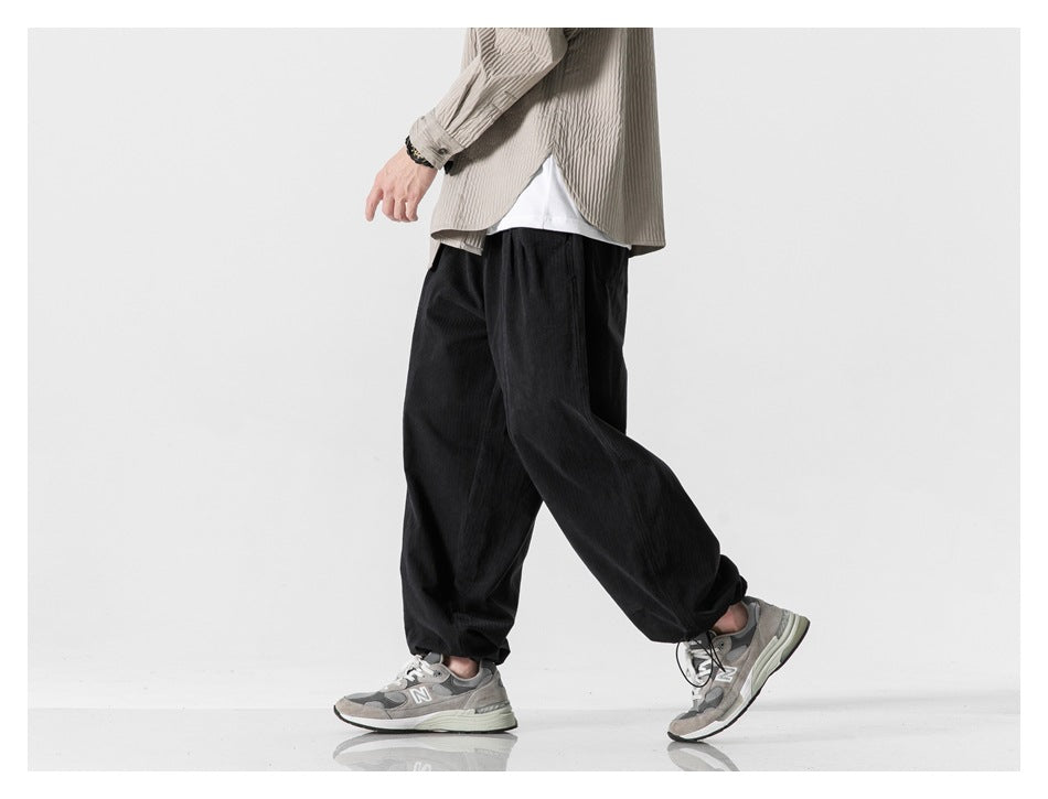 Cropped model walking in black loose-fit pants, shown from the side.