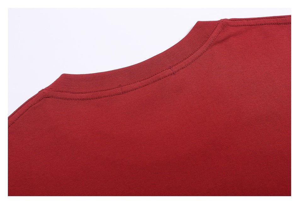 Close-up of the plain dark red T-shirt back neckline and shoulder seams.