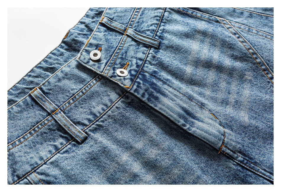 Close-up of light blue jeans showing a buttoned waistband, belt loop and washed denim finish.
