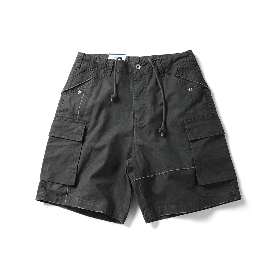 Dark charcoal gray cargo shorts flat lay, front view, with drawstring and large flap thigh pockets