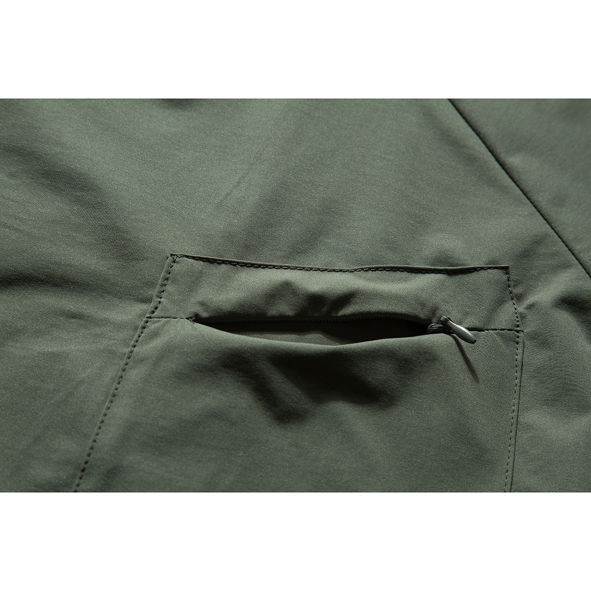 Close-up of a horizontal zip pocket on olive-green shirt fabric.