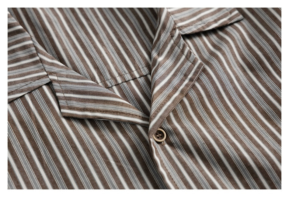 Close-up of the striped shirt's camp collar, front button and stitching in brown, gray and white.