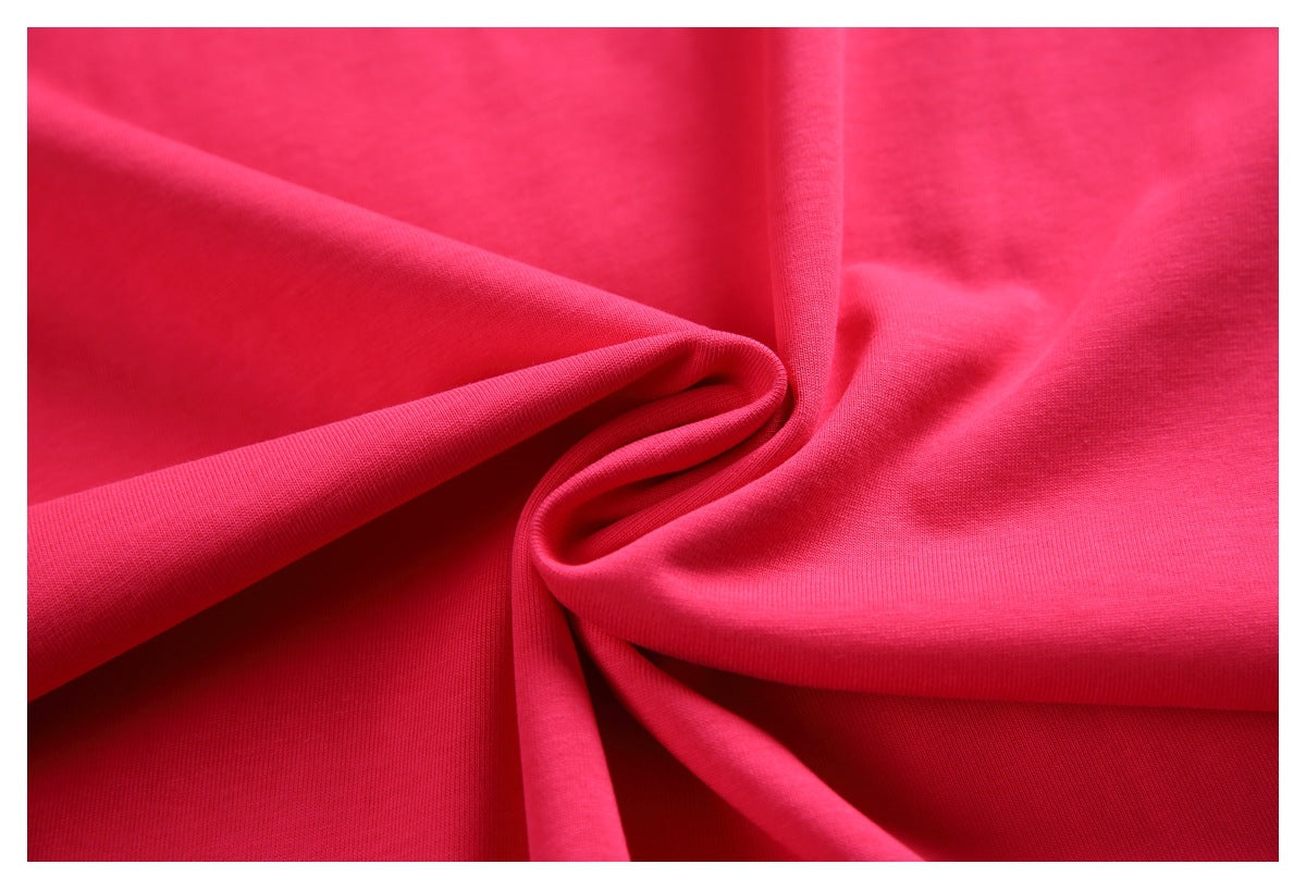 Close-up of bright pink fabric draped into folds, showing its knit texture.