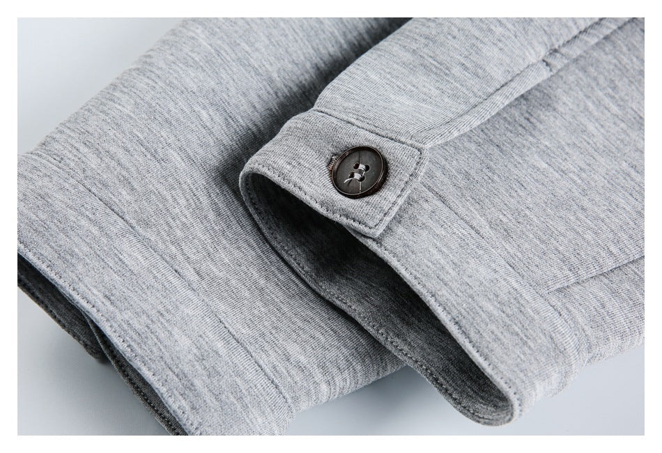 Close-up of a dark button on a heather gray knit fabric tab beside a folded opening.