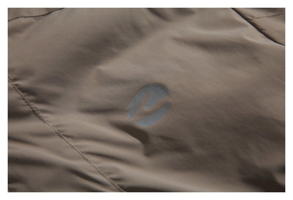 Close-up of a gray emblem on taupe garment fabric with visible stitching.