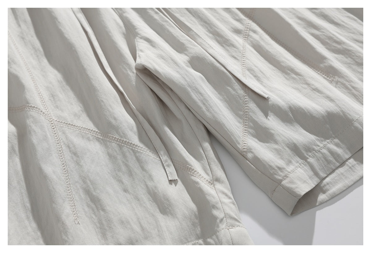 Close-up of off-white shorts showing the drawstring, seam stitching, and hem.
