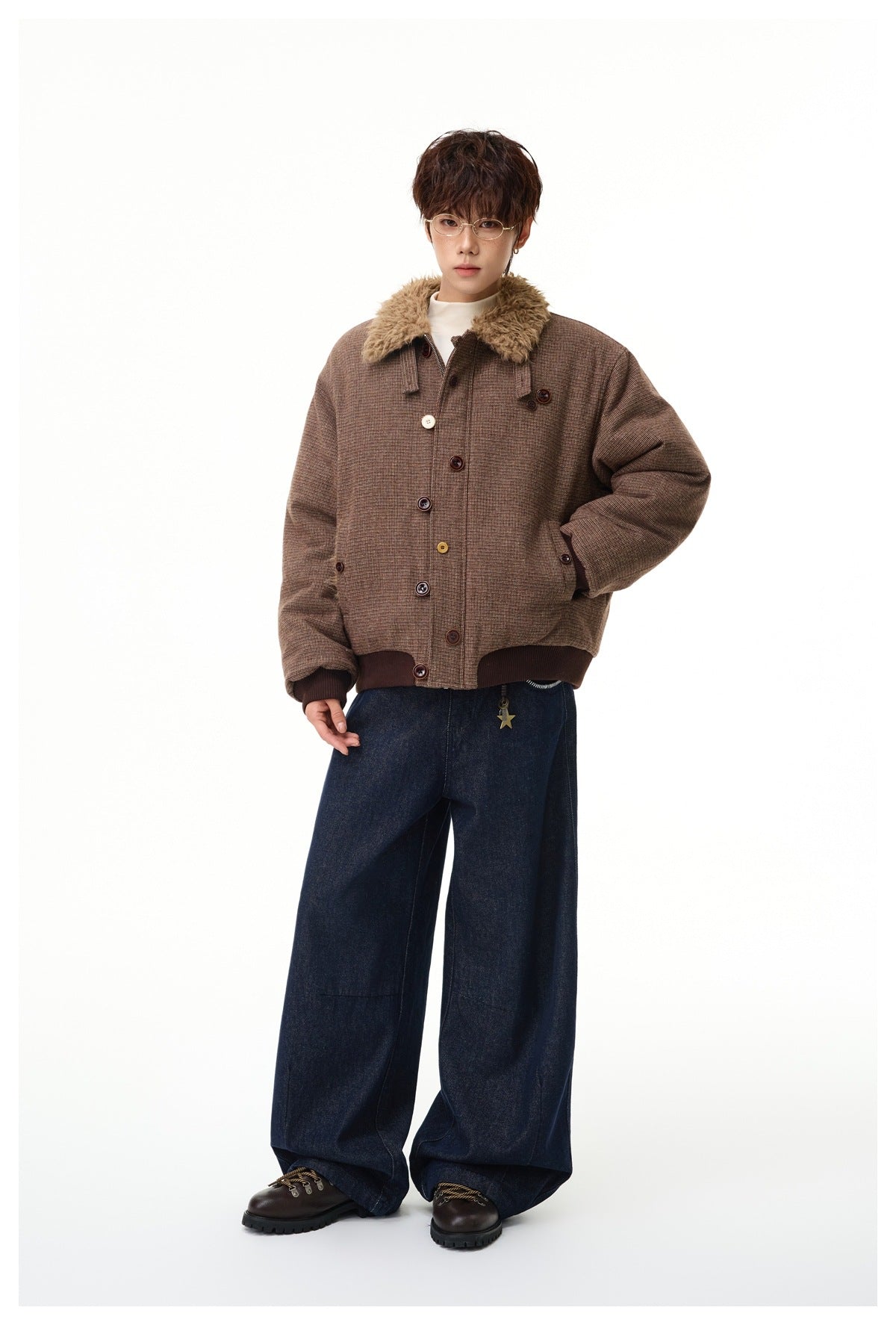Full-length model in a brown checked jacket with plush collar and ribbed trim, styled with wide dark jeans and brown shoes.