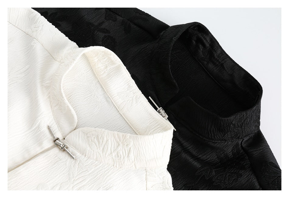 Close-up of the collars and zip closures on ivory and black shirts with textured floral patterns.