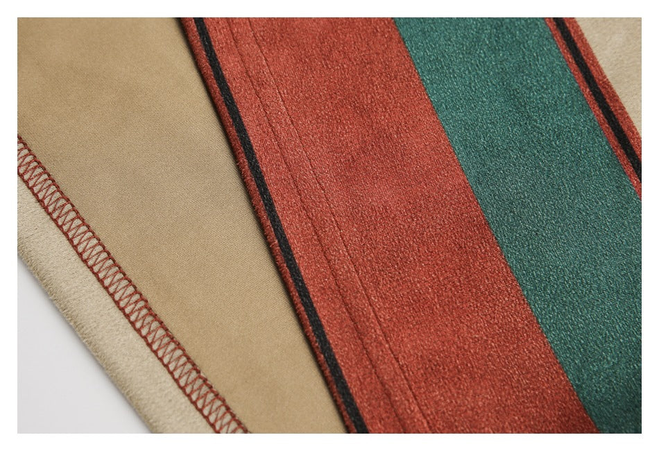 Close-up of striped garment fabric and a beige seam finished with rust-colored stitching.
