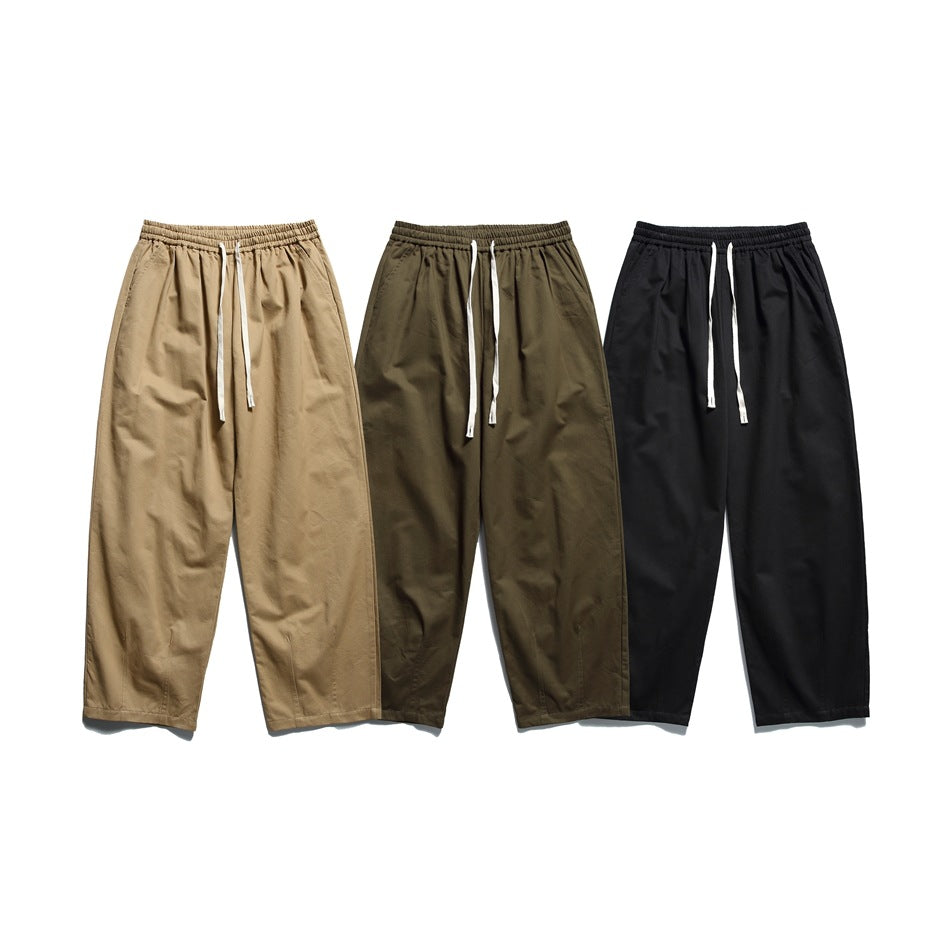 Three pairs of loose-fit drawstring trousers shown from the front in tan, olive and black.