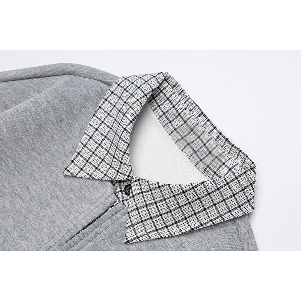 Close-up of a gray sweatshirt's black-and-white plaid collar and partial zipper.