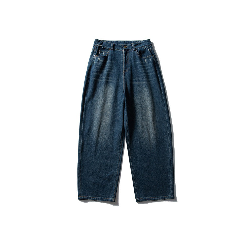Front of blue washed wide-leg denim jeans with zip fly, button, and light distressing, flat on white