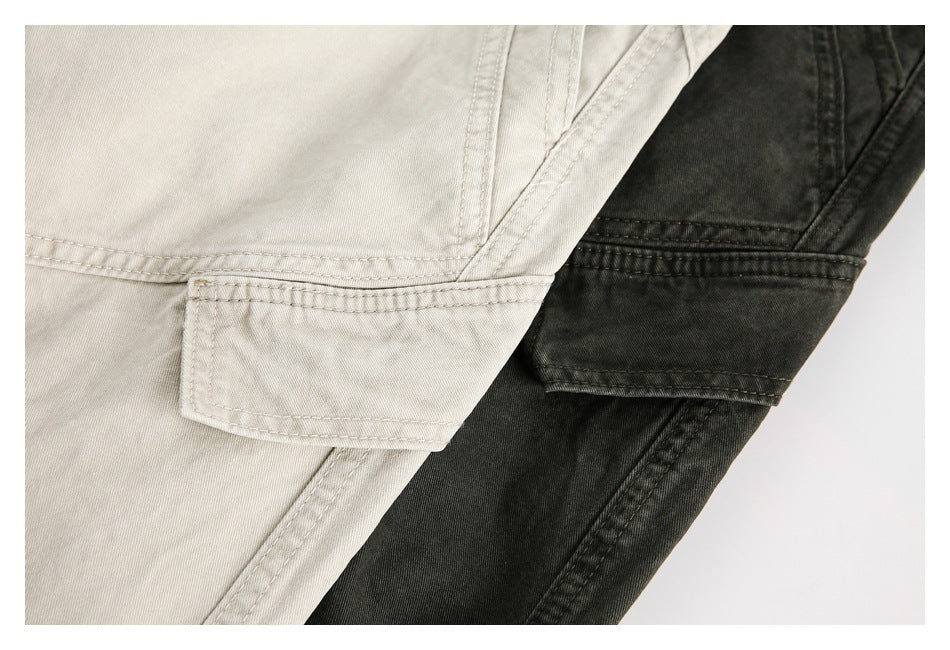Close-up of light beige and charcoal trousers showing stitched pocket flaps and seams.