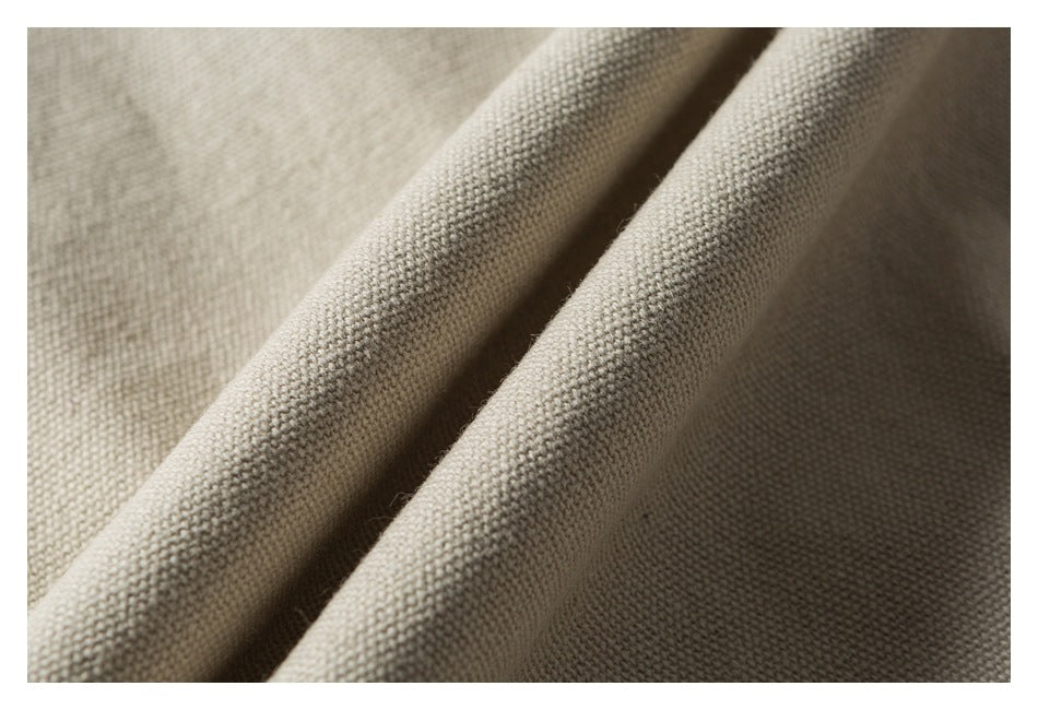 Close-up of beige woven garment fabric draped into soft folds.