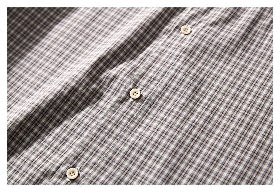Close-up of a gray and cream small-check shirt front with a vertical placket and light buttons.
