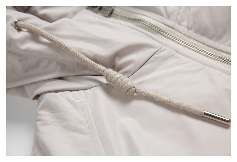 Close-up of a hood drawcord with a knotted adjustment and metal tip against the jacket front.