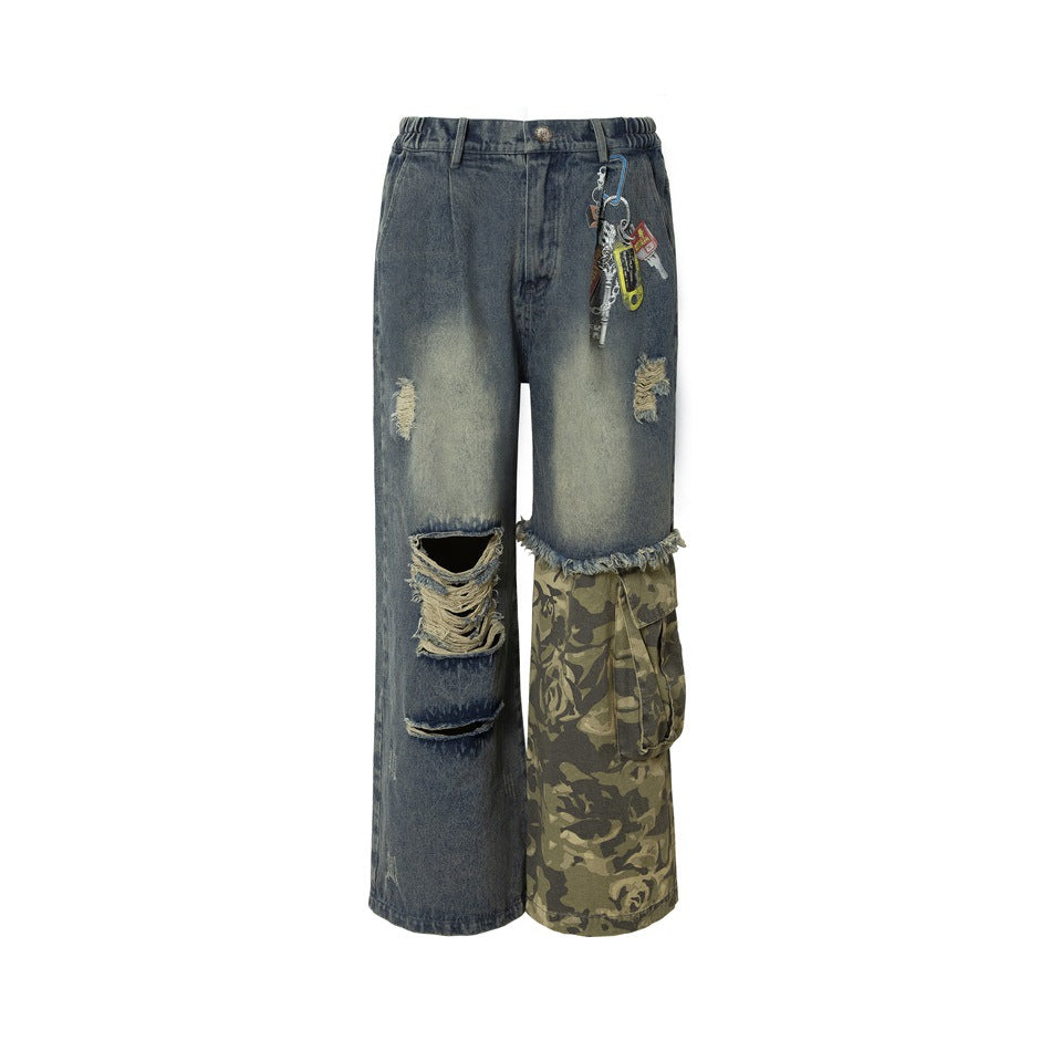 Front of wide-leg blue washed ripped jeans with a camouflage cargo panel on one leg and key charms at the hip