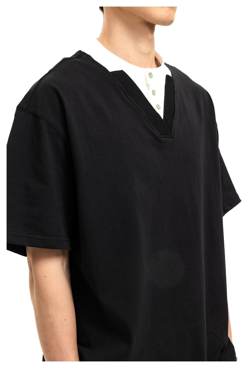 Close-up of a black V-neck top layered over a white shirt with a short button placket.