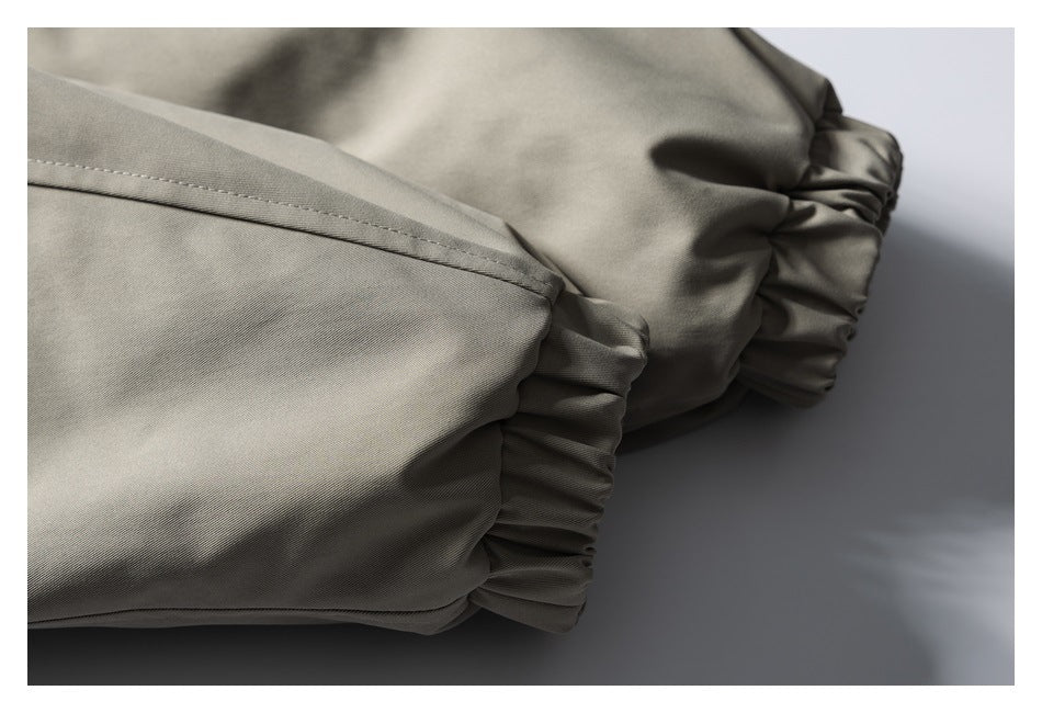 Close-up of taupe-gray garment fabric with stitched seams and gathered elastic edges.