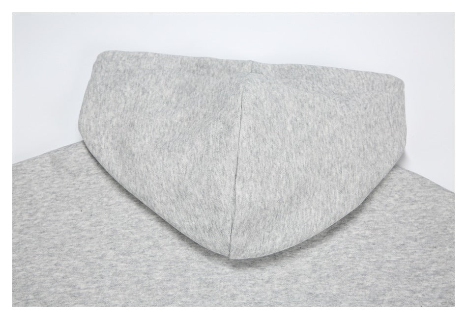 Close-up of a light gray hood resting over matching gray fabric.