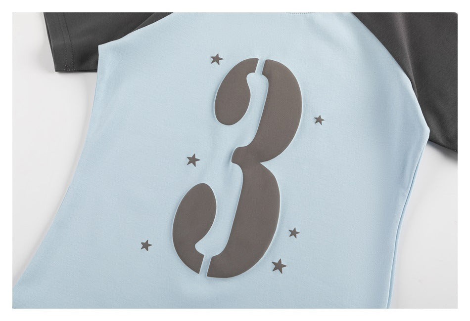 Close-up of a light blue T-shirt front with a large charcoal number 3 and small stars.