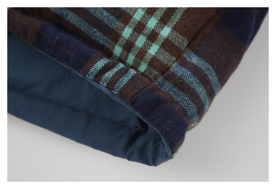 Close-up of a folded edge of brown and navy plaid fabric with pale aqua stripes and dark lining.