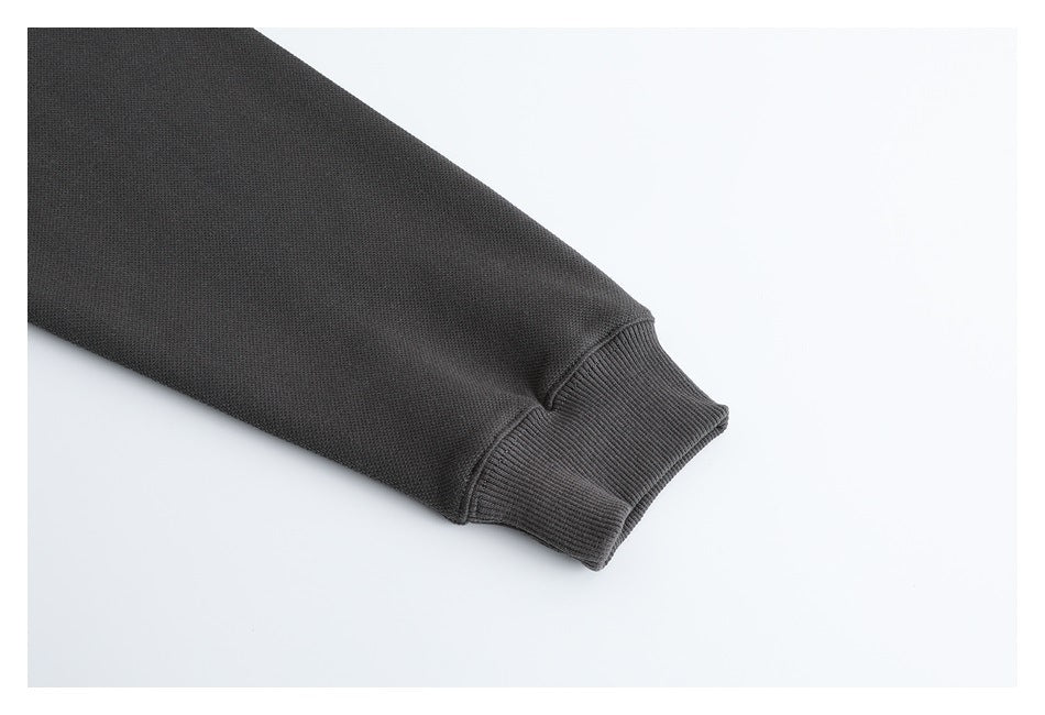 Close-up of the charcoal pullover's sleeve ending in a ribbed cuff.