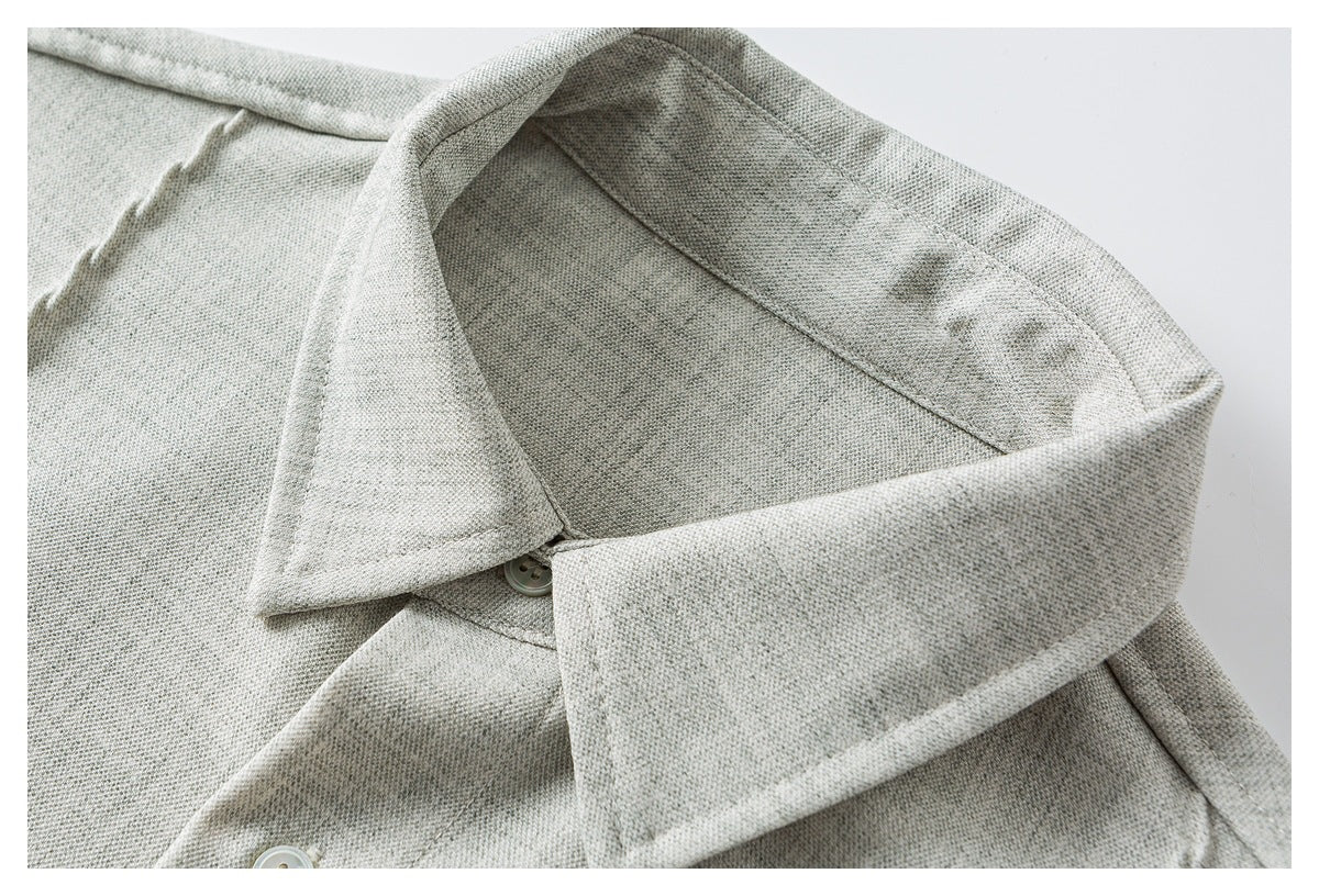 Close-up of a light gray shirt collar and button placket with pale buttons.
