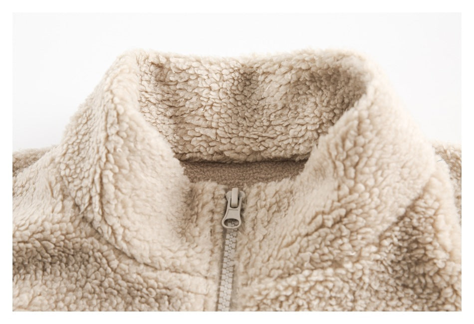 Close-up of a cream fuzzy jacket's folded collar and front zipper.
