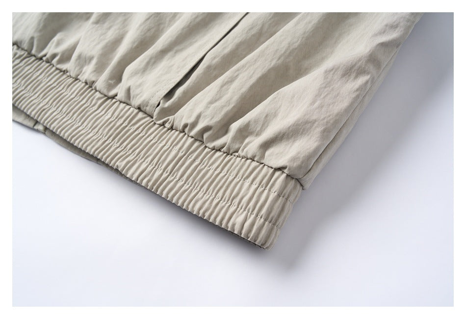 Close-up of the light beige-gray jacket’s gathered elastic hem.