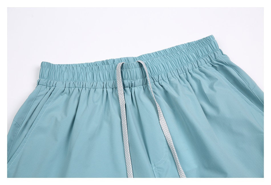 Close-up of the shorts' gathered elastic waistband and white drawstrings.