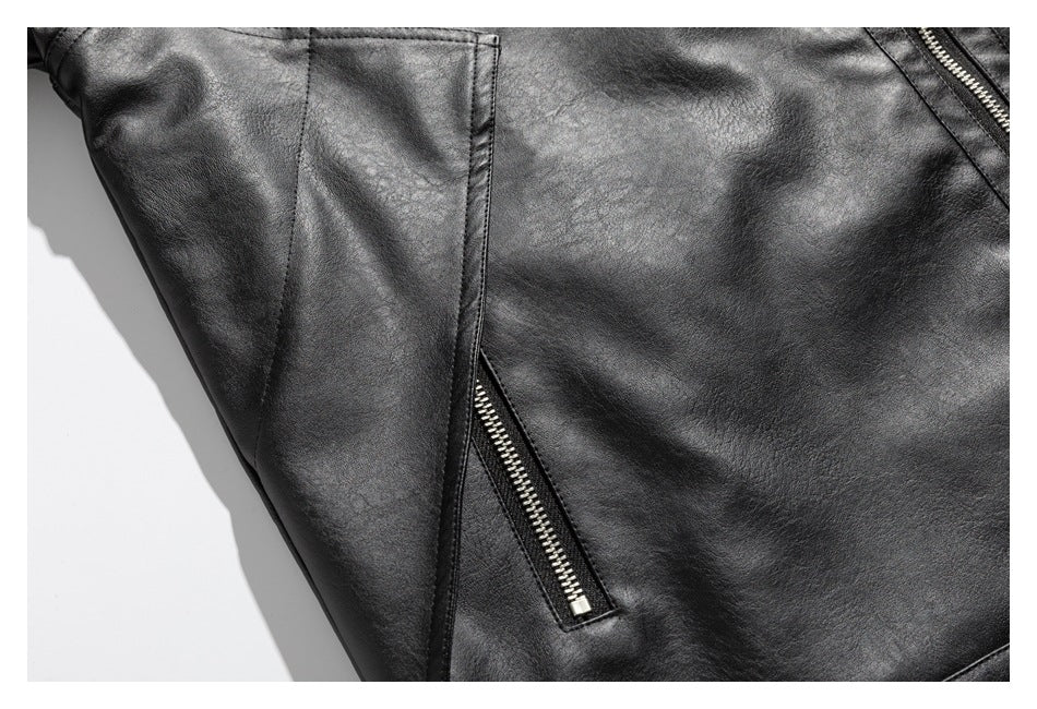 Close-up of a diagonal zip pocket and panel seams on a black jacket.