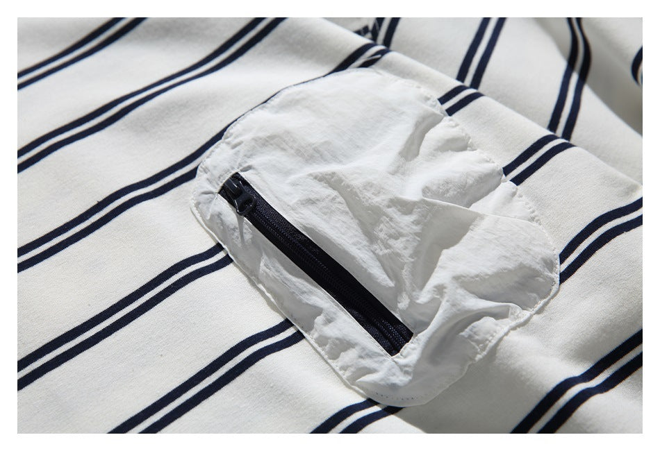 Close-up of a white utility chest pocket with a navy zipper on the striped top.