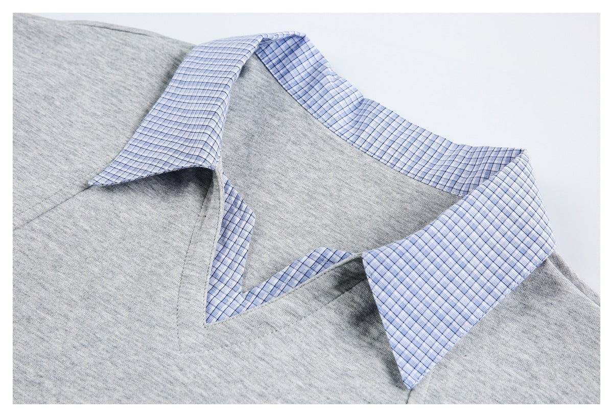 Close-up of the blue checked collar and V-neck opening on a light gray top.