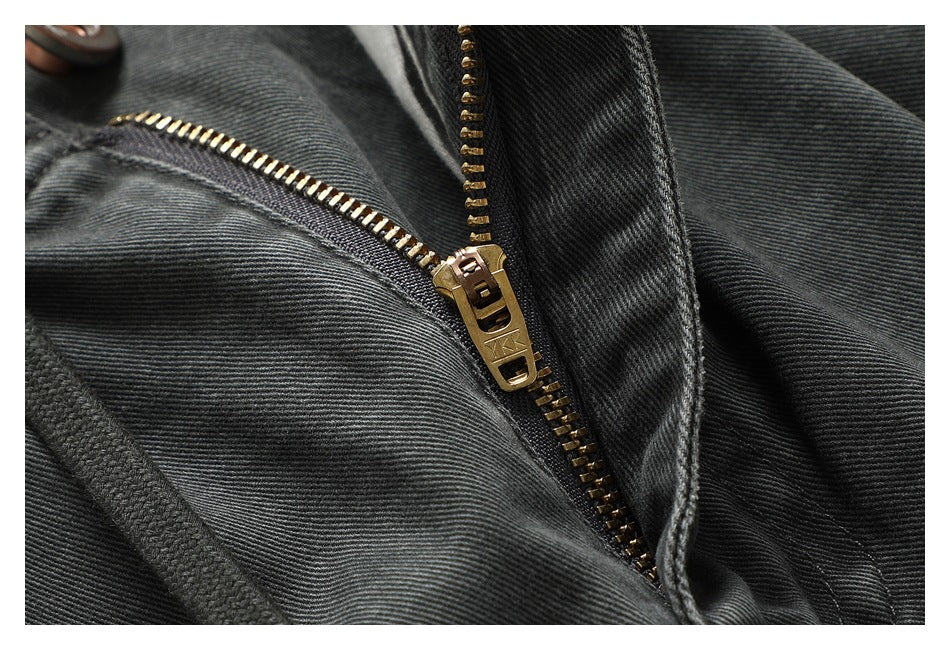 Close-up of charcoal shorts with a gold-tone zipper, drawstring and stitched seams.