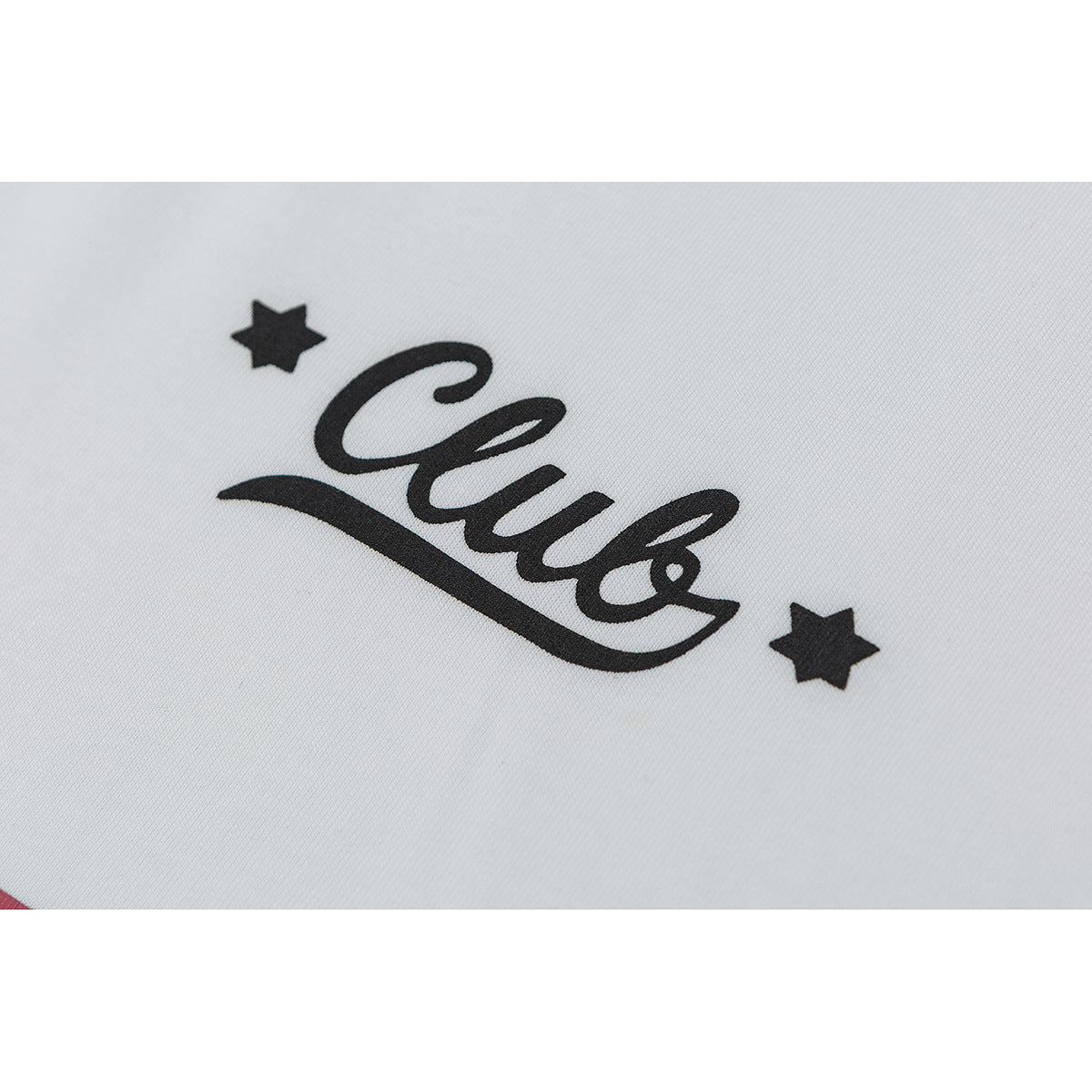 Close-up of a black script-and-star graphic printed on white shirt fabric.