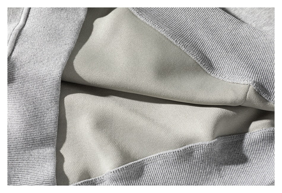 Close-up of the inside of a gray sweatshirt, showing the smooth inner surface and ribbed edges.