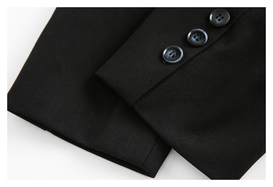 Close-up of a black garment sleeve with three glossy black buttons along the cuff.