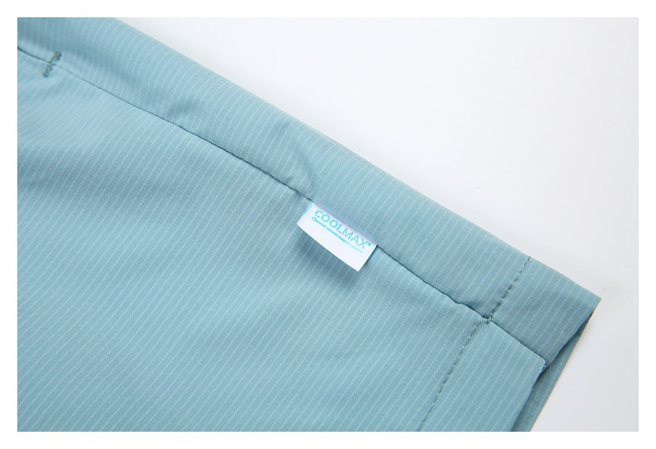 Close-up of light blue pinstriped garment seams with a sewn-in COOLMAX label.