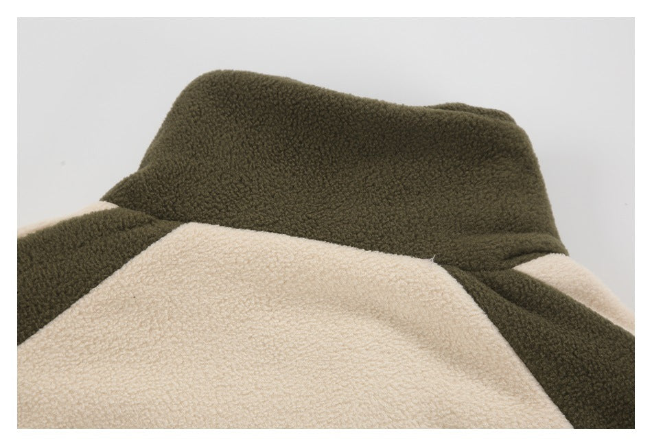 Close-up of an olive and cream color-blocked garment with a raised collar.