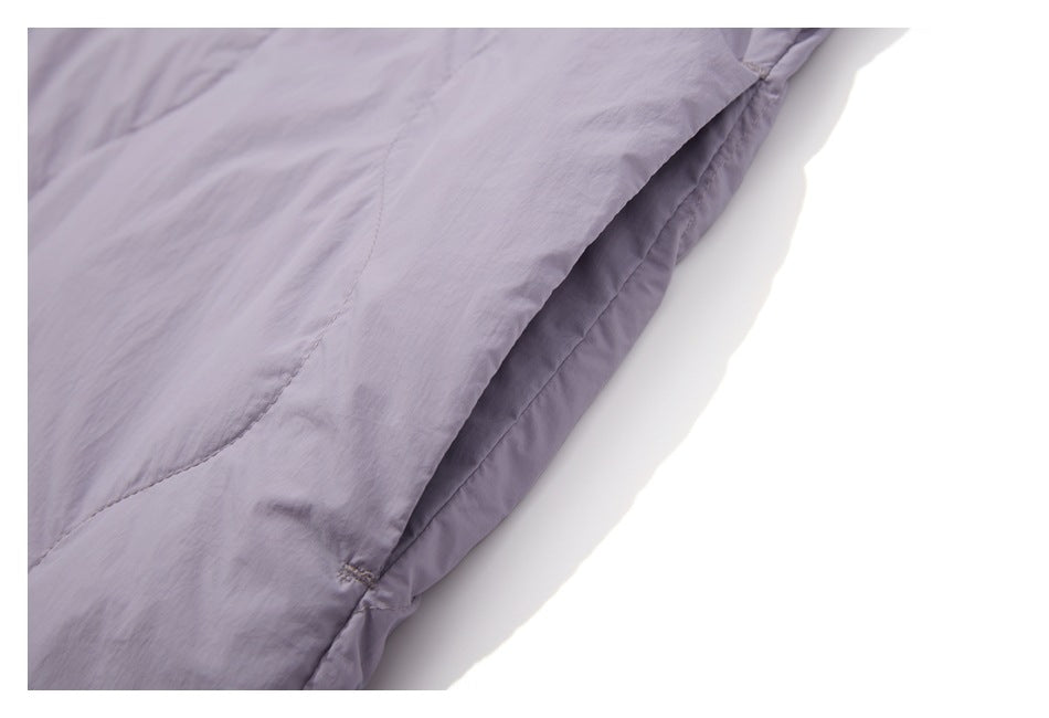Close-up of pale lavender garment fabric with a curved stitched seam and folded edge.